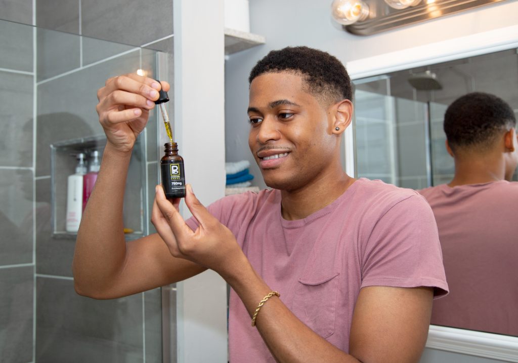 Creator Tyler Jurelle holding a Physicians Grade CBD wellness product.
