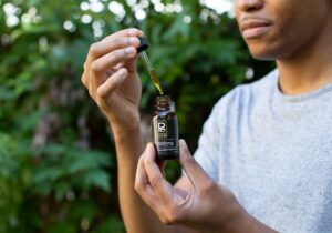 With his face barely shown, Tyler Jurelle models Physicians Grade CBD oil, emphasizing their quality.