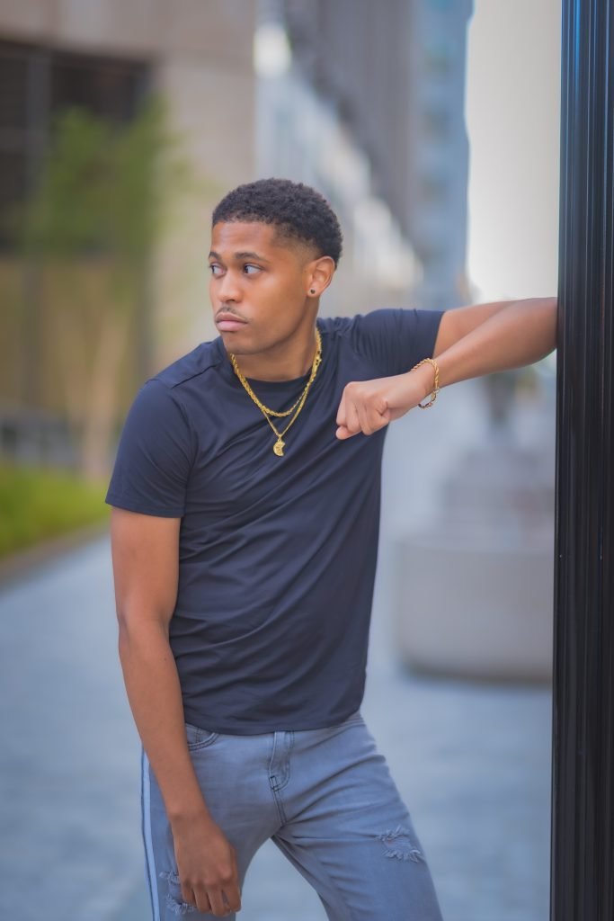 Tyler Jurelle showcases a modern urban look with Craftd London rope gold chain, bracelet, and St. Christopher pendant.