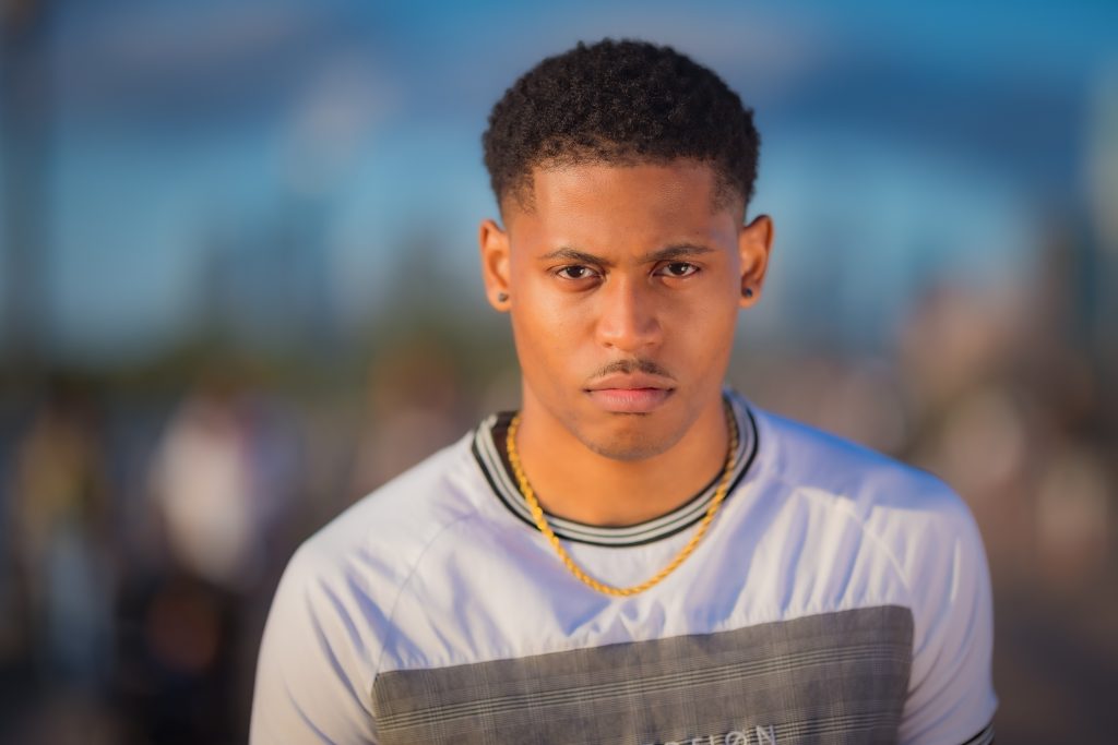 Close-up headshot of Tyler Jurelle wearing a Craftd London rope gold chain, taken at Liberty State Park in Jersey City.