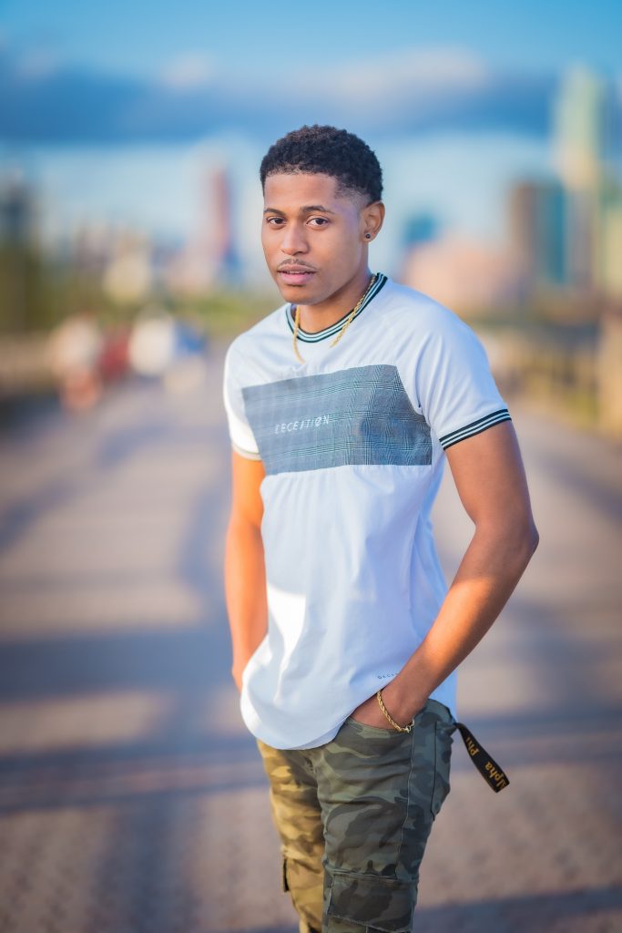 Mid-body shot of Tyler Jurelle showcasing the Deception Toronto Miami Plaid Tee and Craftd London gold chain, photographed in Jersey City.