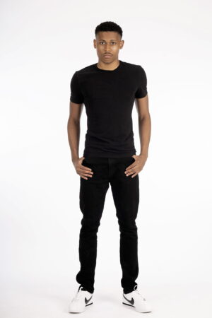 Full body shot of Tyler Jurelle wearing an all-black outfit, standing confidently against a white backdrop.