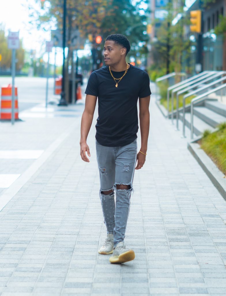 Aaron Robinson captures Tyler Jurelle in Downtown Jersey City, wearing a black T-shirt and PRSTGE light gray track jeans.