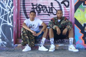 Tyler Jurelle and Joshua model Royal One Soul’s coordinated streetwear, displaying a unified urban style.