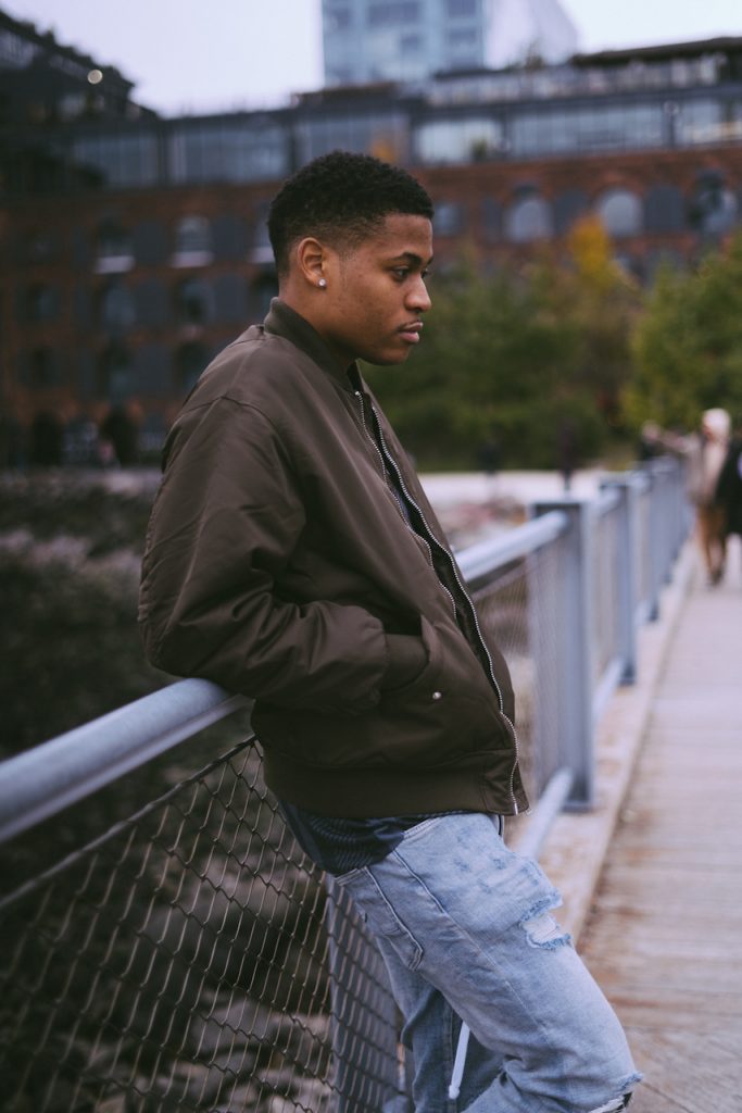 A stylish stance in Biker Patch Denim and a bomber jacket against the Brooklyn Bridge backdrop.