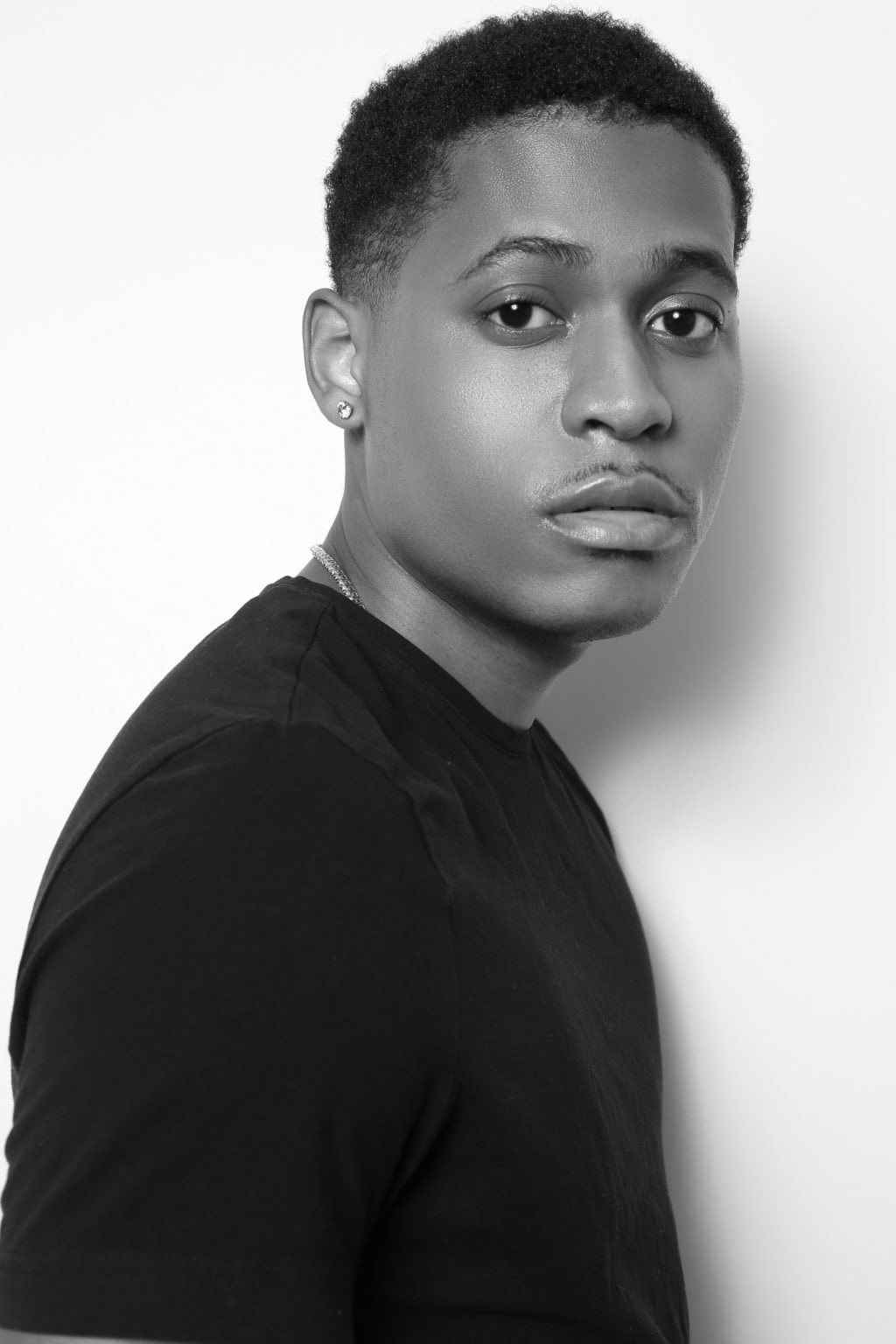Jorge Pagan Jr. captured a striking black-and-white headshot of Tyler Jurelle wearing a plain black T-shirt, exuding intensity.