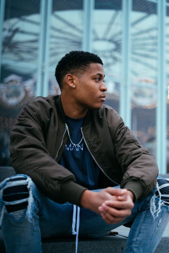 Casual vibes in denim and a bomber jacket, Tyler Jurelle is soaking in the views at Brooklyn Bridge Park.