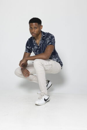 A studio shot of freelance male model Tyler Jurelle highlighting the balance of casual and stylish elements in summer fashion.