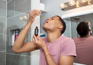 Tyler Jurelle presents Physicians Grade CBD oil, highlighting its features with a clear view of his face.