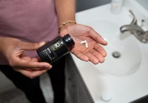 Hand-modeling Physicians Grade CBD capsules, emphasizing the product's sleek design.