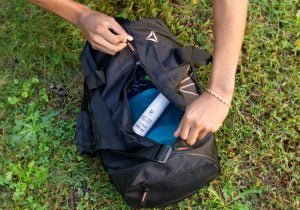 Tyler Jurelle unzips a duffle bag to reveal a Physicians Grade CBD balm, focusing on the product’s visibility.