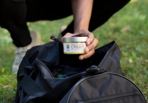 Tyler Jurelle holds a jar of Physicians Grade CBD cream, taken out of the duffle bag, emphasizing the product’s premium quality.