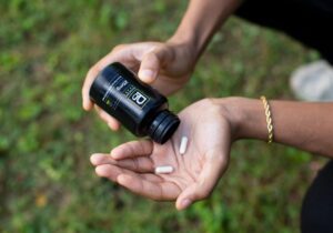Close-up of a hand holding Physicians Grade CBD capsules, showcasing their quality.