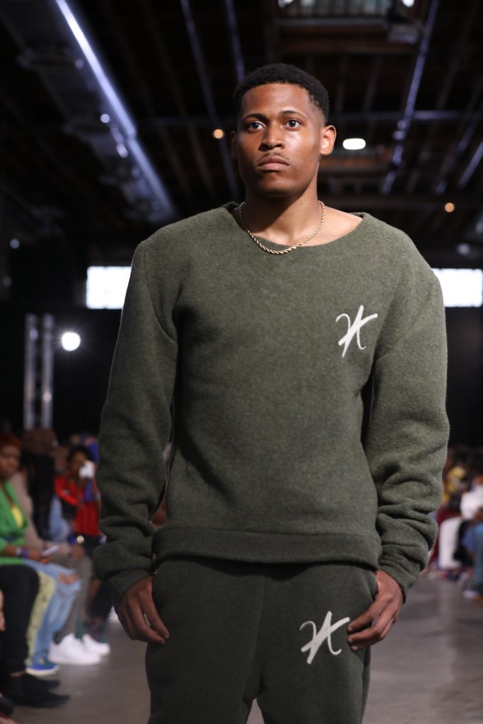 Capturing the moment of confidence while walking down the runway in a khaki green wool set.