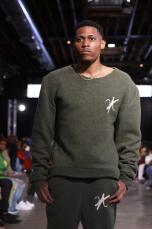 Capturing the moment of confidence while walking down the runway in a khaki green wool set.