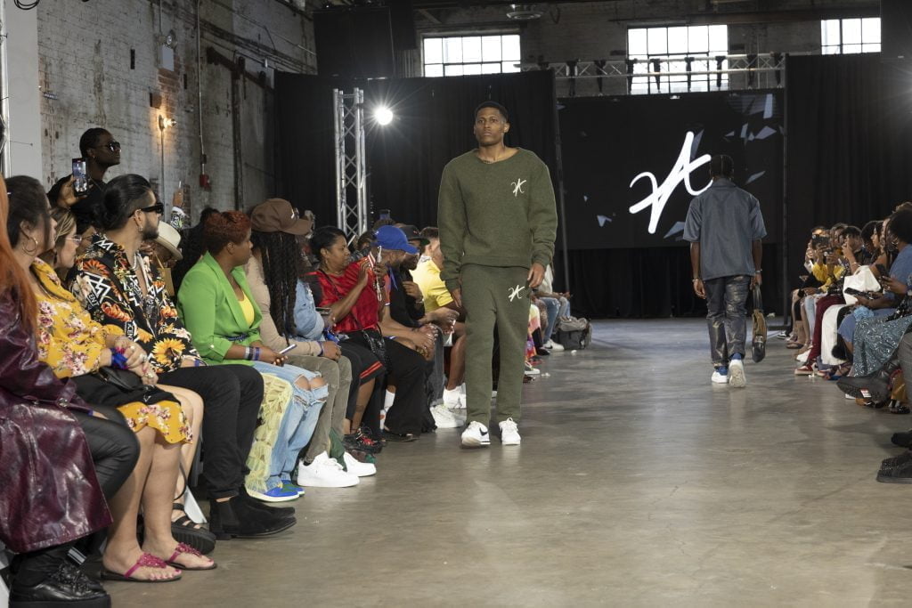 Men's fashion expert Tyler Jurelle is elegantly walking down the runway in Vaughn Acquis’s wool set.