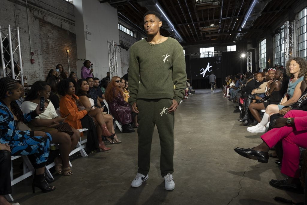 Balancing grace and groundedness on the catwalk, Tyler Jurelle is modeling Vaughn Acquis’s collection.