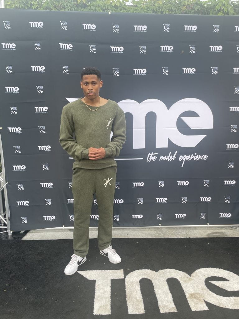 In a quiet moment before the show, Tyler reflects in a khaki green wool set by Vaughn Acquis.
