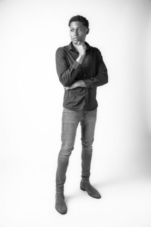 A black-and-white image capturing Tyler Jurelle rocking a classic denim style paired with a dark button-up shirt.