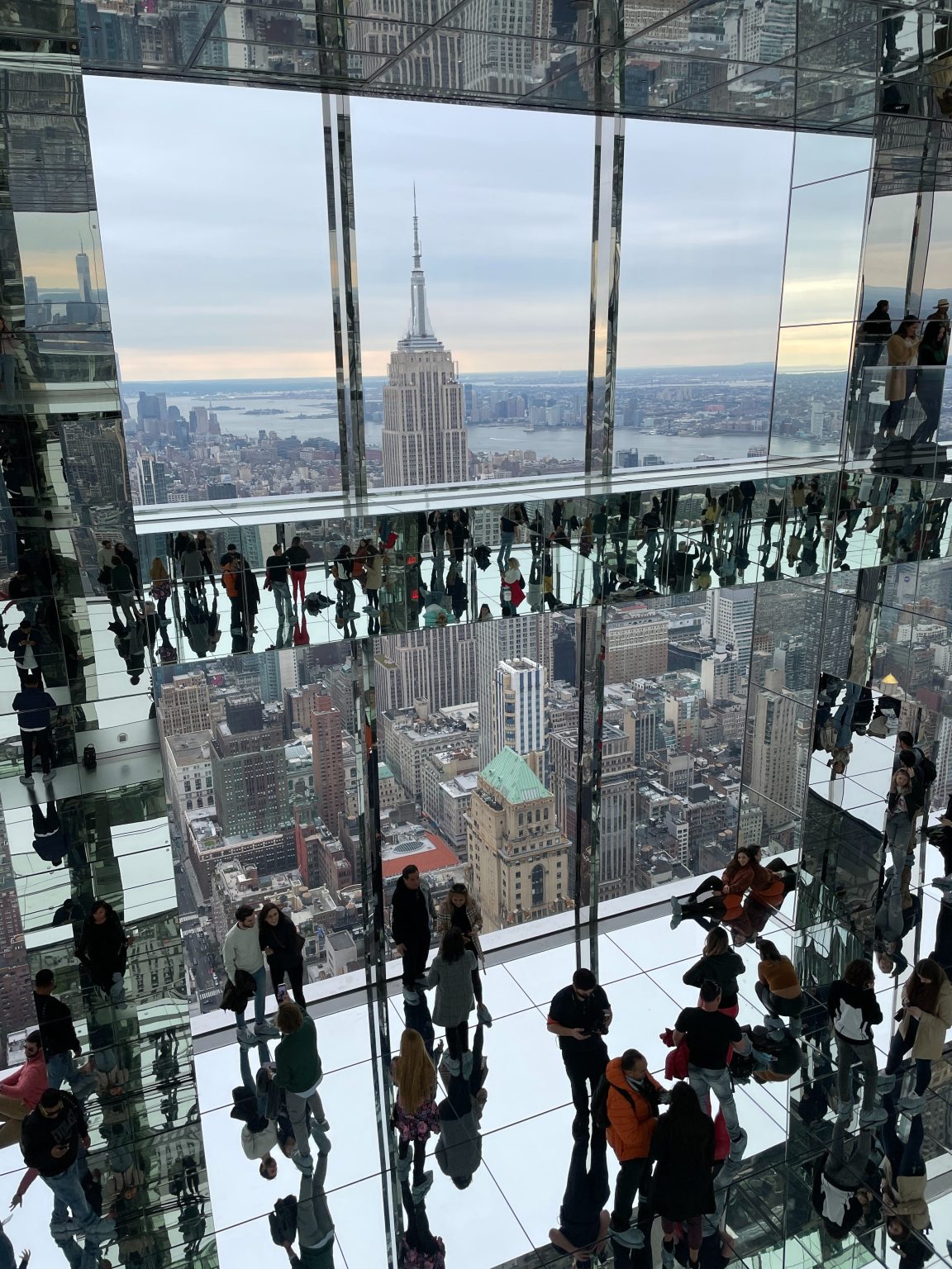 The mirror glass reflective interior of the One Vanderbilt observatory with a view of the Empire State Building in New York City.