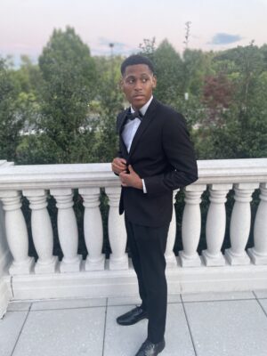 Making a formal event presence, Tyler Jurelle dons a suit and bow tie, looking sharp and poised.