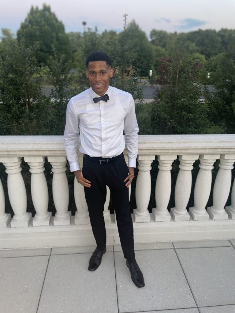 Tyler Jurelle showcases a sleek look in a suit and bow tie, highlighting his style without the blazer.