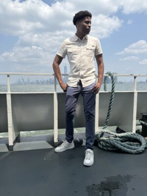 With the New York City skyline as a backdrop, Tyler Jurelle enjoys the harbor views from the boat.