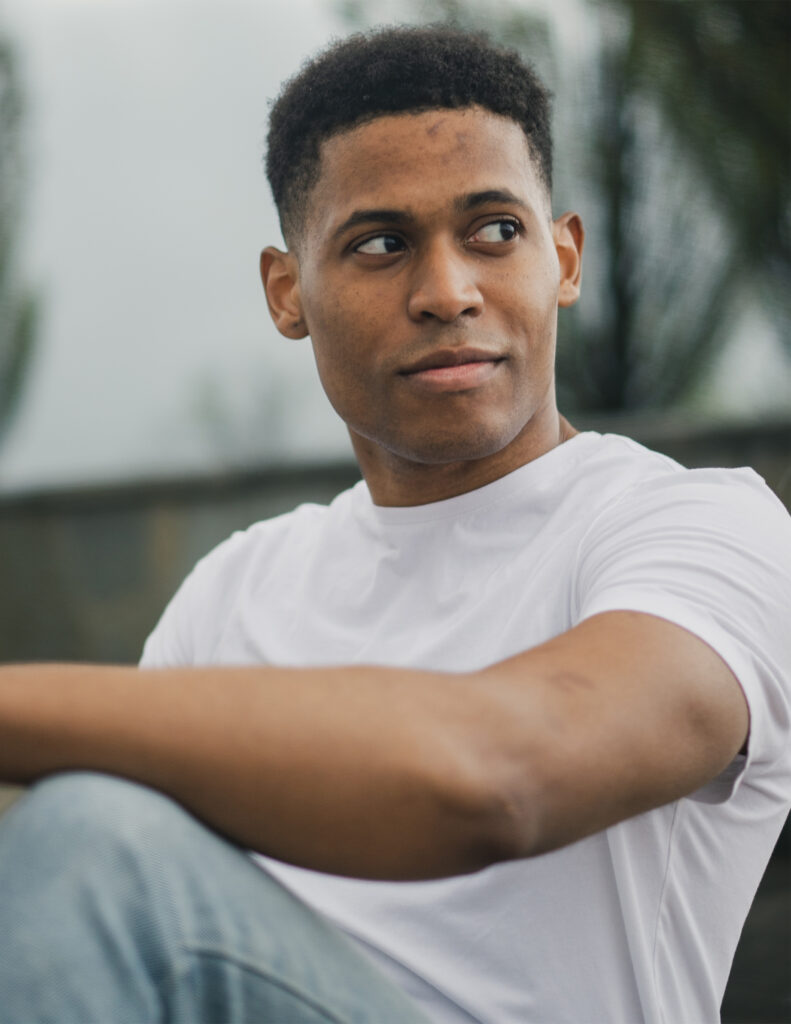 A close-up shot of Tyler Jurelle sitting down, dressed in a white t-shirt.