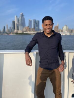 Lifestyle Creator Tyler Jurelle is smiling with the NYC skyline in view while on a Circle Line Sightseeing Cruise.