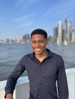 Tyler Jurelle is behind the scenes of a commercial shoot with Circle Line Sightseeing Cruise in NYC with the skyline in the background.