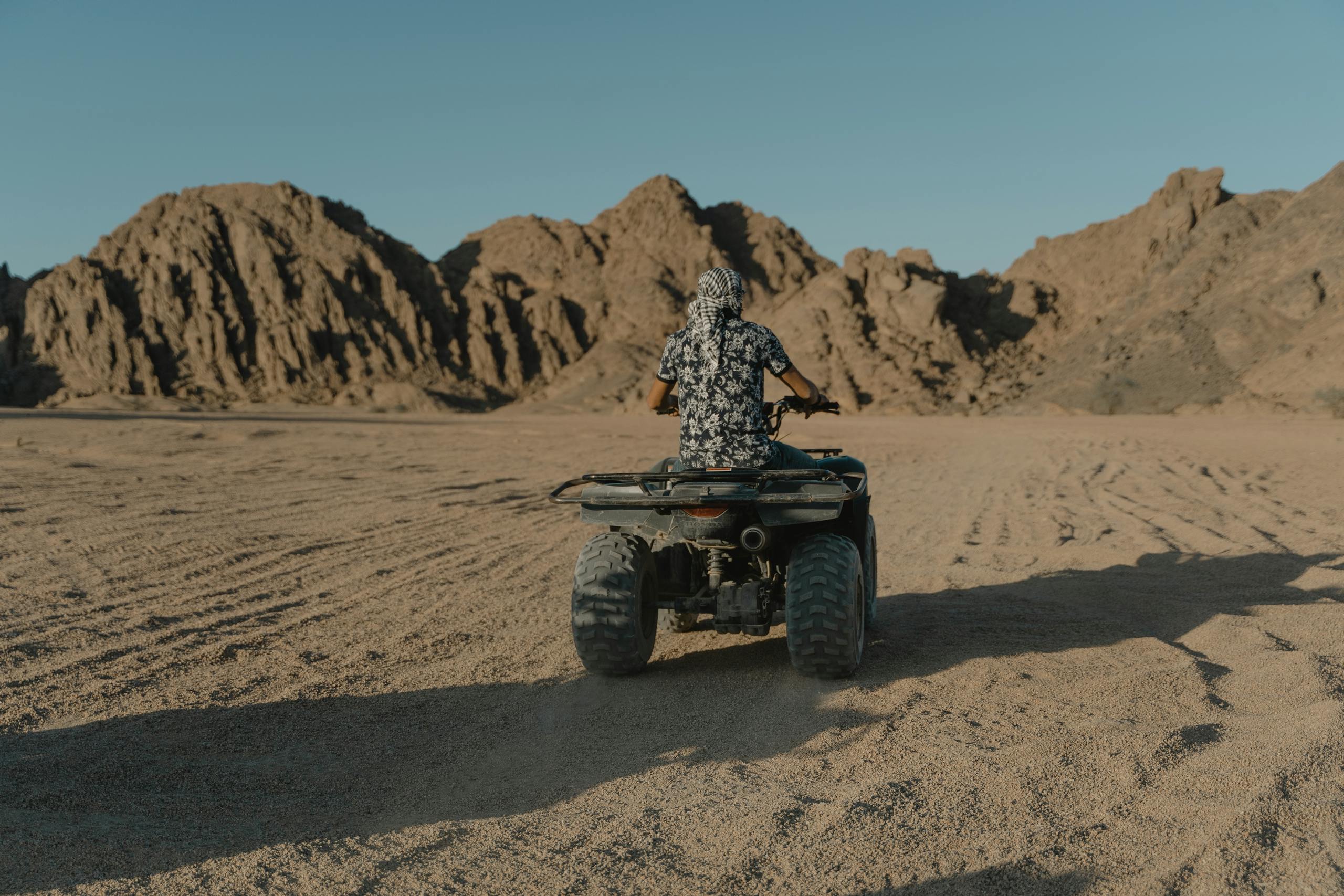 Person riding ATV through a rugged desert, showcasing outdoor adventure and stunning scenery. Check out all of my travel activity recommendations from brands like Agoda, Viator, Booking.com, Expedia, and more.